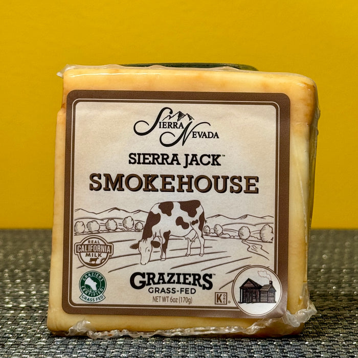 Block of Sierra Nevada Sierra Jack Smokehouse cheese with packaging on a textured surface.