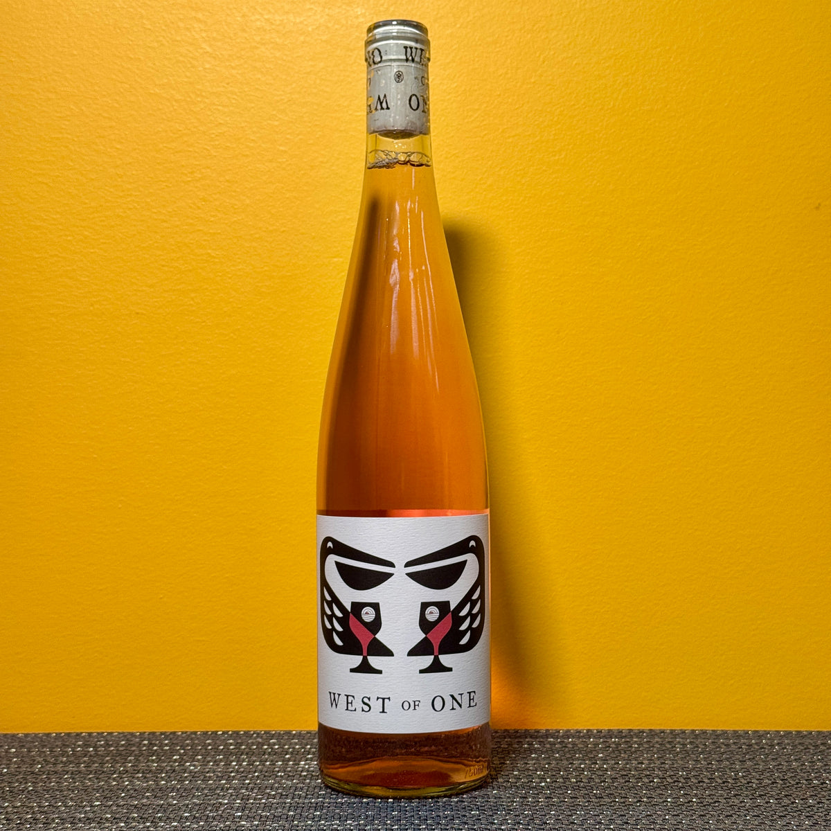 Bottle of West of One wine against a yellow background